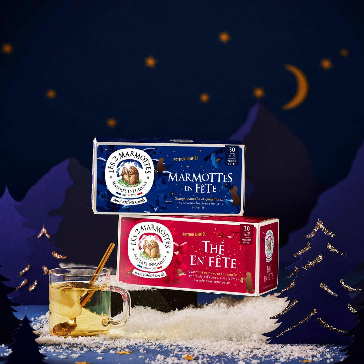 Idée cadeau secret santa pour fan de thé : 1 thé de noel + 1 tisane de noel Les  2 Marmottes. Recettes 100% plantes, sans arômes ajoutés, fabrication française Les 2 Marmottes. Jolies boîtes décor festif doré sur fond rouge ou bleu.